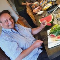Der talk2move Geschäftsführer schneidet eine Wassermelone