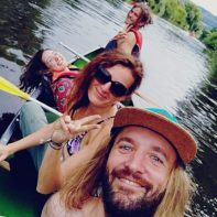 Vier Personen paddeln über einen Fluss
