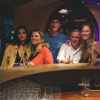 mehrere Mitarbeiter sitzen mit Getränken an der Bar