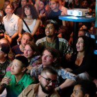 Fundraiser sitzen auf dem Boden und schauen gespannt den Ehrungen zu