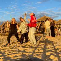 Drei Fundraiser tanzen am Strand