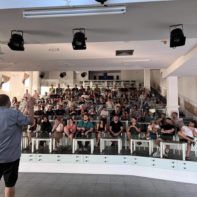 Eine große Gruppe von talk2move Mitarbeitern hört einer Ansprache vom Geschäftsführer zu