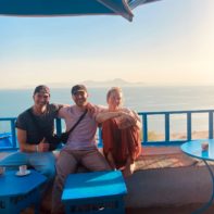 Drei Fundraiser sitzen zusammen auf einer Terasse am Strand