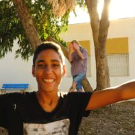 Ein tunesischer Junge strahlt in die Kamera und streckt dabei die Arme in die Luft