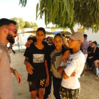Ein Fundraiser unterhält sich mit drei Jungen aus dem SOS-Kinderdorf