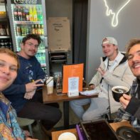 Vier Fundraiser sitzen in einem Café und genießen diverse Heißgetränke