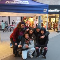 Fünf Fundraiser posieren vor einem blauen Plan Stand