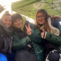 Drei Fundraiserinnen mit grünen SOS-Kinderdorf Jacken an einem Infostand