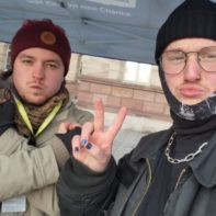 Zwei Fundraiser posieren unter einem Plan-Infostand