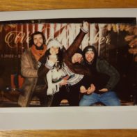 Polaroid Foto von drei Fundraisern, die eine weitere Fundraiserin tragen