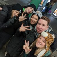 Fünf Fundraiser mit WWF Mützen halten drei Finger in die Luft