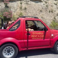 Mehrere Personen sitzen in einem roten Geländewagen mit der Aufschrift Instanbul Rent A Car.